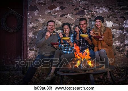 Portrait of two mature couples eating in front of campfire at night View Large Photo Image Stock Image - Portrait of two mature couples eating in front of campfire at night. Fotosearch