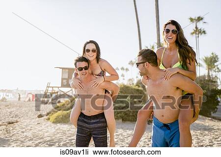 Portrait of two young men giving girlfriends a piggyback on Newport Beach, California, USA View Large Photo Image Stock Image - Portrait of two young men giving girlfriends a piggyback on Newport Beach, California, USA. Fotosearch