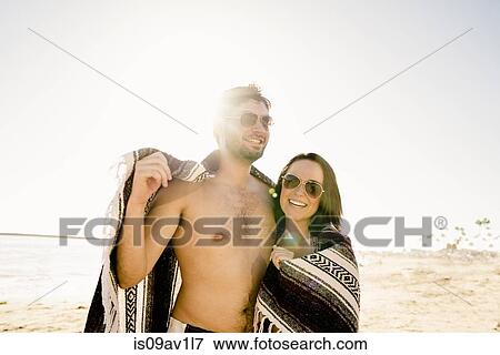 Portrait of young couple wrapped in blanket on Newport Beach, California, USA View Large Photo Image Stock Photo - Portrait of young couple wrapped in blanket on Newport Beach, California, USA. Fotosearch