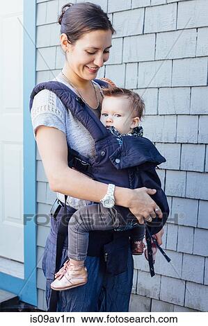 Portrait of young woman carrying baby daughter in sling on porch View Large Photo Image Picture - Portrait of young woman carrying baby daughter in sling on porch. Fotosearch