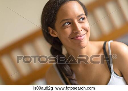 Portrait of young woman, hair plaited, looking away smiling View Large Photo Image Stock Image - Portrait of young woman, hair plaited, looking away smiling. Fotosearch