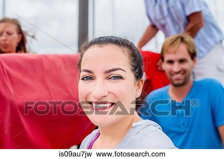 Portrait of young woman, hair tied back looking at camera smiling View Large Photo Image Stock Photo - Portrait of young woman, hair tied back looking at camera smiling. Fotosearch