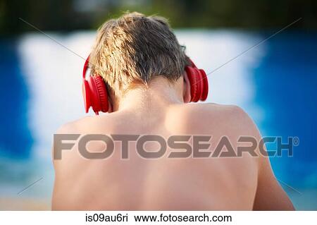 Rear head and shoulder view of teenage boy wearing headphones at poolside View Large Photo Image Stock Image - Rear head and shoulder view of teenage boy wearing headphones at poolside. Fotosearch