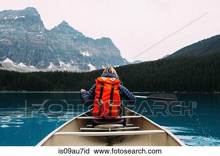 Rear view of mid adult woman paddling canoe, Moraine lake, Banff National Park, Alberta Canada View Large Photo Image Stock Image - Rear view of mid adult woman paddling canoe, Moraine lake, Banff National Park, Alberta Canada. Fotosearch