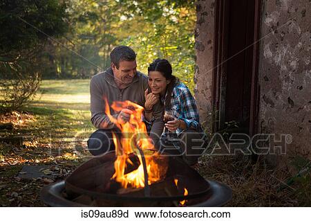 Romantic mature couple crouching by garden campfire View Large Photo Image Stock Image - Romantic mature couple crouching by garden campfire. Fotosearch
