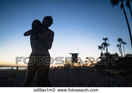 Stock Image - Romantic young couple hugging at sunset, Newport Beach, California, USA. Fotosearch