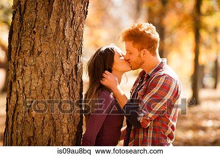 Romantic young couple kissing in autumn forest View Large Photo Image Stock Photography - Romantic young couple kissing in autumn forest. Fotosearch