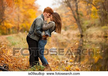 Stock Photography - Romantic young couple on riverside in autumn. Fotosearch