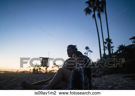 Romantic young couple sitting on beach watching sunset, Newport Beach, California, USA View Large Photo Image Stock Image - Romantic young couple sitting on beach watching sunset, Newport Beach, California, USA. Fotosearch