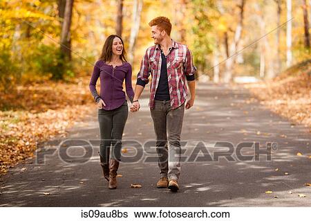 Stock Photograph - Romantic young couple strolling in autumn forest. Fotosearch