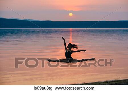 Side view of girl by ocean at sunset leaping in mid air, arms raised doing the splits View Large Photo Image Stock Image - Side view of girl by ocean at sunset leaping in mid air, arms raised doing the splits. Fotosearch