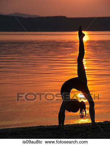 Side view of girl in silhouette by ocean at sunset bending over backwards leg raised doing the splits View Large Photo Image Stock Image - Side view of girl in silhouette by ocean at sunset bending over backwards leg raised doing the splits. Fotosearch