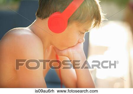 Side view of teenage boy wearing headphones at poolside View Large Photo Image Stock Image - Side view of teenage boy wearing headphones at poolside. Fotosearch
