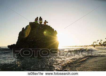 Silhouette of adult friends on rock formation at sunset, Newport Beach, California, USA View Large Photo Image Stock Photo - Silhouette of adult friends on rock formation at sunset, Newport Beach, California, USA. Fotosearch