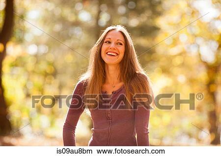 Sunlit portrait of long haired young man in autumn forest View Large Photo Image Picture - Sunlit portrait of long haired young man in autumn forest. Fotosearch