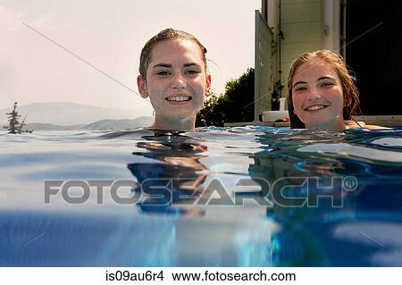 Surface level portrait of teenage girls in outdoor swimming pool View Large Photo Image Picture - Surface level portrait of teenage girls in outdoor swimming pool. Fotosearch