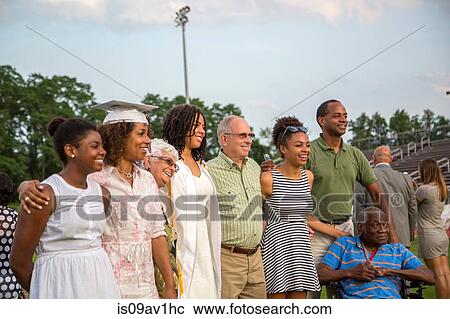 Stock Image - Teenage girl with large family at graduation ceremony. Fotosearch