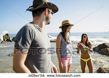 Three adult friends playing American football in sea at Newport Beach, California, USA View Large Photo Image Stock Image - Three adult friends playing American football in sea at Newport Beach, California, USA. Fotosearch