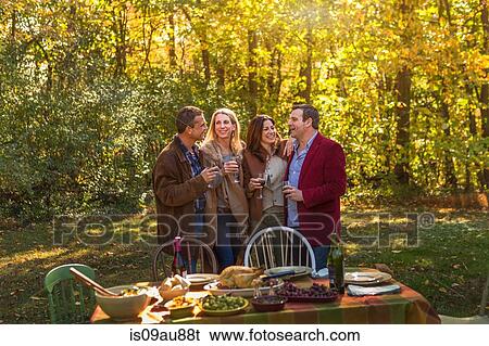 Two mature couples chatting at garden dinner party View Large Photo Image Stock Photograph - Two mature couples chatting at garden dinner party. Fotosearch
