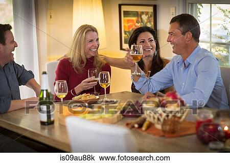 Two mature couples drinking wine and chatting at dinner party View Large Photo Image Stock Image - Two mature couples drinking wine and chatting at dinner party. Fotosearch