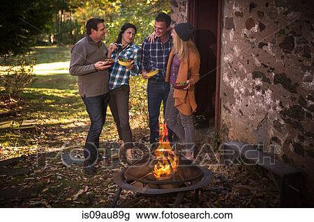 Two mature couples eating in front of campfire in garden View Large Photo Image Stock Image - Two mature couples eating in front of campfire in garden. Fotosearch