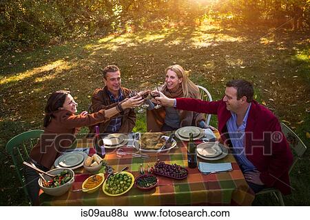 Two mature couples making a toast at garden dinner party View Large Photo Image Stock Photograph - Two mature couples making a toast at garden dinner party. Fotosearch