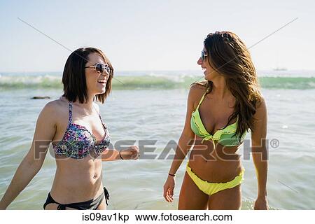 Stock Photography - Two young female friends in sea at Newport Beach, California, USA. Fotosearch