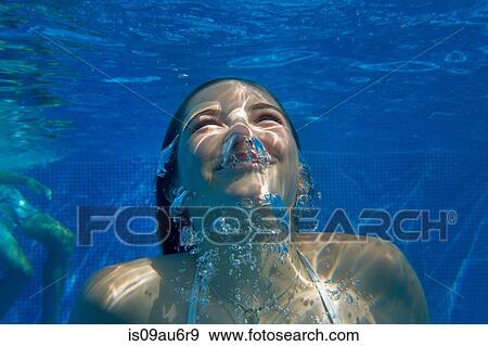 Stock Photo - Underwater head and shoulder view of girl underwater swimming in swimming pool. Fotosearch