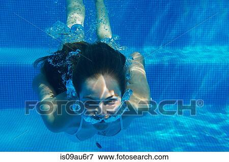 Underwater portrait of girl underwater swimming in swimming pool View Large Photo Image Stock Photo - Underwater portrait of girl underwater swimming in swimming pool. Fotosearch