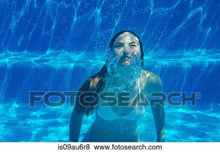 Underwater view of girl underwater swimming in swimming pool View Large Photo Image Stock Photo - Underwater view of girl underwater swimming in swimming pool. Fotosearch