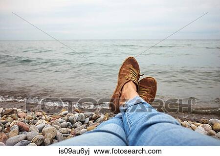 Woman relaxing on pebble beach, low section View Large Photo Image Stock Image - Woman relaxing on pebble beach, low section. Fotosearch