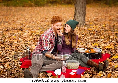 Young couple having picnic in autumn forest View Large Photo Image Stock Image - Young couple having picnic in autumn forest. Fotosearch