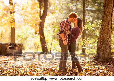 Stock Photography - Young couple kissing in autumn forest. Fotosearch