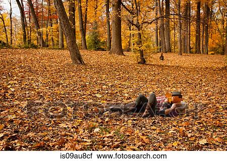 Stock Image - Young couple play fighting in autumn forest. Fotosearch