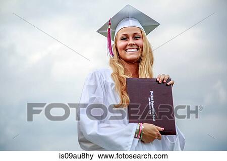 Young female graduate holding certificate at graduation ceremony View Large Photo Image Stock Photo - Young female graduate holding certificate at graduation ceremony. Fotosearch