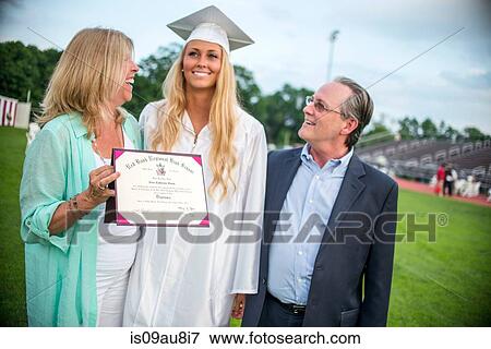 Stock Photo - Young female graduate with parents at graduation ceremony. Fotosearch