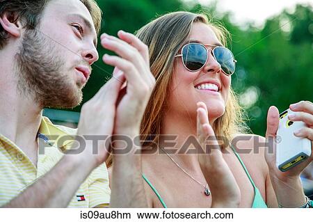 Young man and teenage sister clapping at graduation ceremony View Large Photo Image Picture - Young man and teenage sister clapping at graduation ceremony. Fotosearch