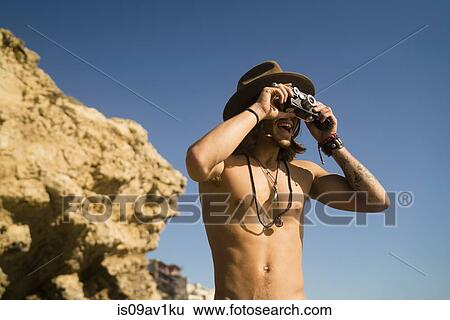 Young man photographing from cliff at Newport Beach, California, USA View Large Photo Image Stock Photograph - Young man photographing from cliff at Newport Beach, California, USA. Fotosearch