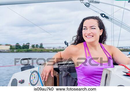 Young woman wearing vest on sailboat looking away smiling View Large Photo Image Stock Image - Young woman wearing vest on sailboat looking away smiling. Fotosearch