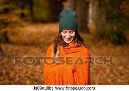 Young woman wrapped in orange blanket in autumn forest View Large Photo Image Stock Photograph - Young woman wrapped in orange blanket in autumn forest. Fotosearch