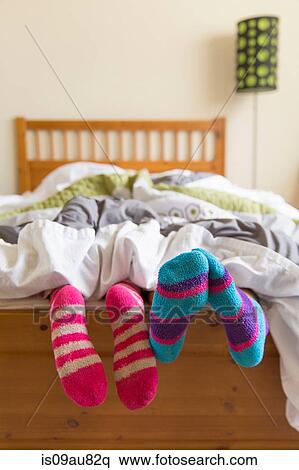 Young women in bed underneath quilt, socked feet sticking out of bed View Large Photo Image Stock Photography - Young women in bed underneath quilt, socked feet sticking out of bed. Fotosearch