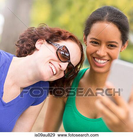Young women using smartphone to take sefie smiling View Large Photo Image Stock Photo - Young women using smartphone to take sefie smiling. Fotosearch