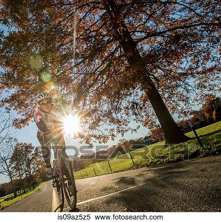 Angled view of cyclist cycling in sunlight View Large Photo Image Stock Photography - Angled view of cyclist cycling in sunlight. Fotosearch
