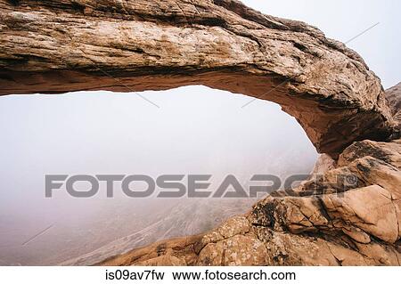 Stock Photo - Arch rock formation in mist, Moab, Utah, USA. Fotosearch