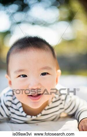 Baby boy lying on stomach outdoors View Large Photo Image Stock Image - Baby boy lying on stomach outdoors. Fotosearch