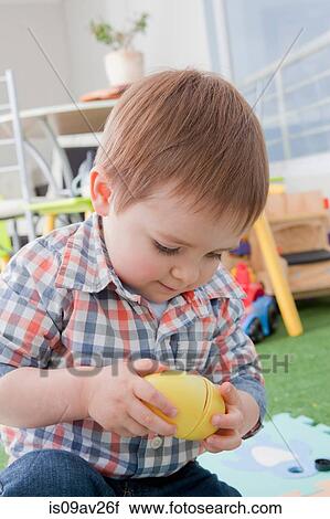 Stock Image - Baby boy playing with toys at home. Fotosearch