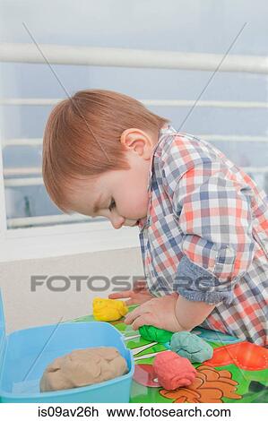 Stock Image - Baby boy playing with toys at home. Fotosearch