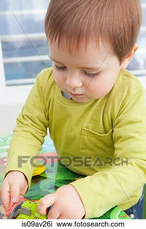 Stock Image - Baby boy playing with toys at home. Fotosearch