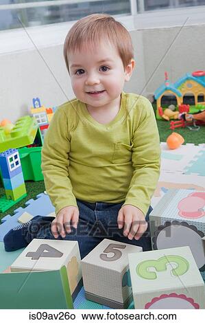 Picture - Baby boy stacking playing blocks at home. Fotosearch