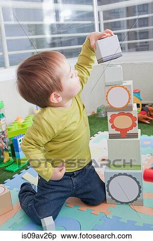 Baby boy stacking playing blocks at home View Large Photo Image Stock Photography - Baby boy stacking playing blocks at home. Fotosearch